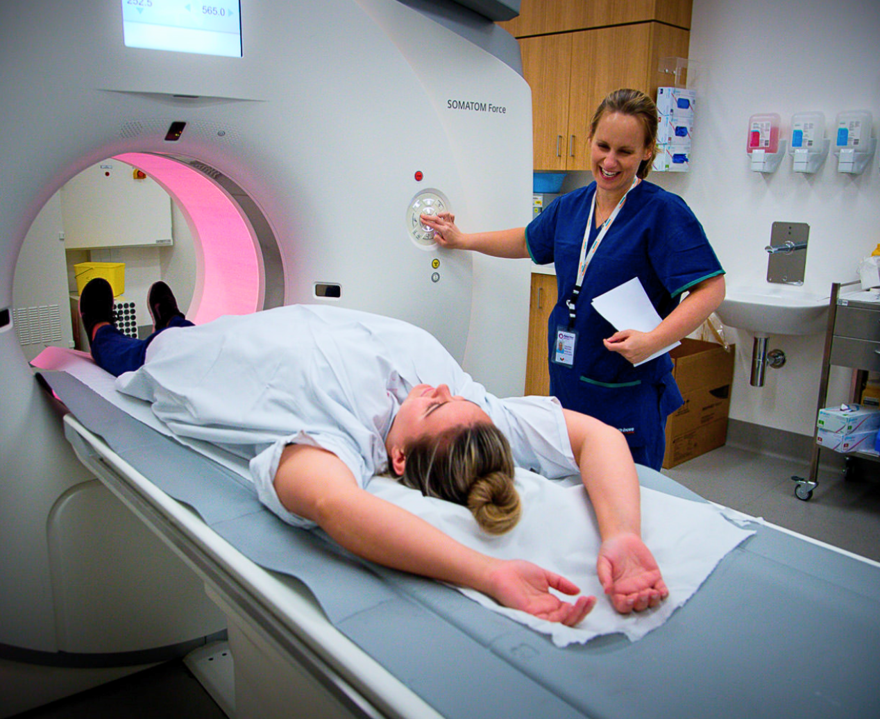 A female patient is laying down, about to receive an MRI scan.