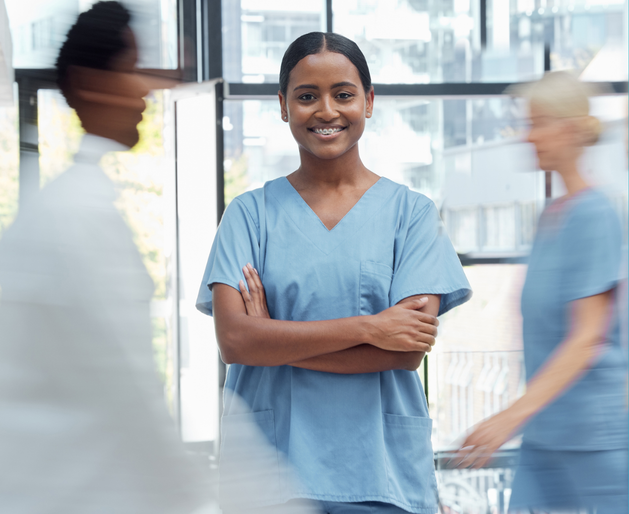 A medical radiation practitioner wearing blue scrubs, smiling at the camera.
