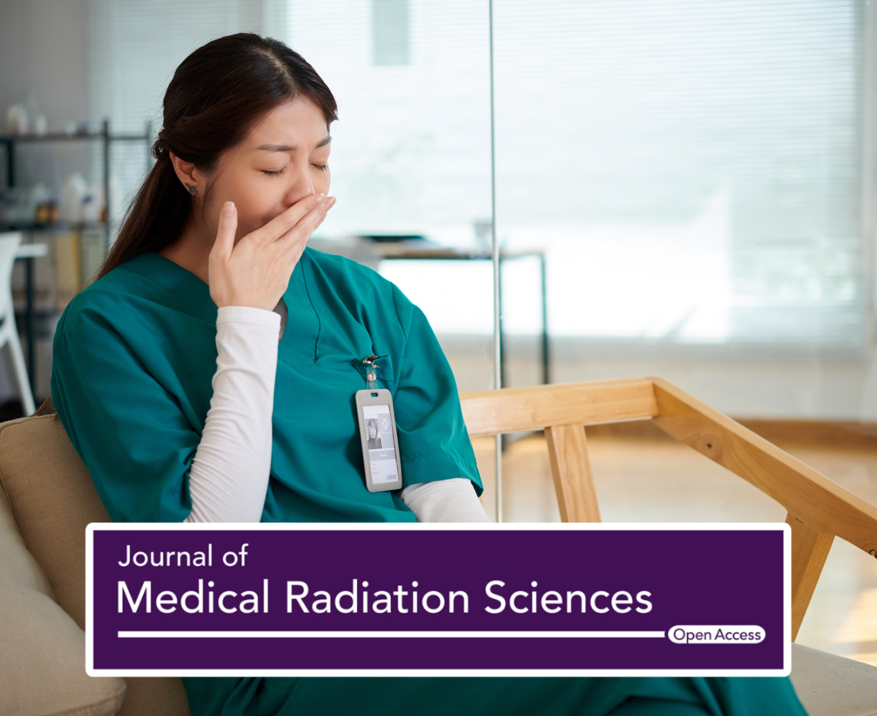 A young radiography student is sitting down and yawning at the hospital